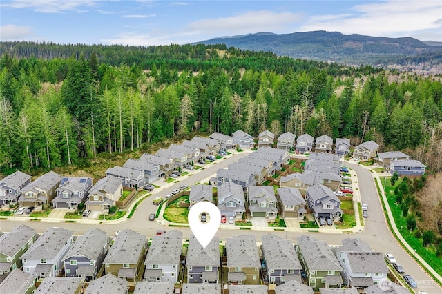 drone / aerial view featuring a residential view, a mountain view, and a forest view