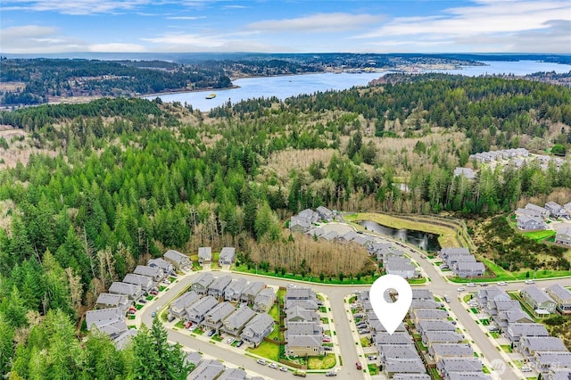 drone / aerial view featuring a residential view, a view of trees, and a water view