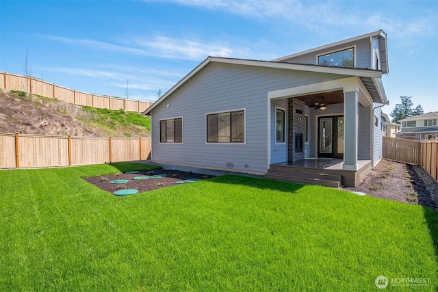 back of house featuring a yard, a fenced backyard, and ceiling fan