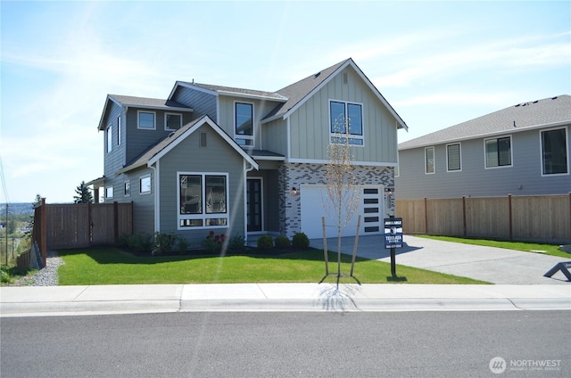 craftsman inspired home featuring concrete driveway, fence, board and batten siding, and a garage