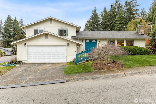 tri-level home with aphalt driveway, a garage, a front yard, and stucco siding