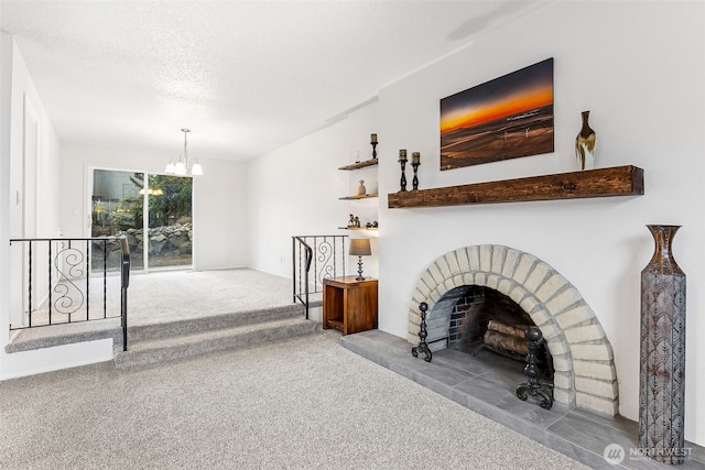 living area with a chandelier, a brick fireplace, a textured ceiling, and carpet