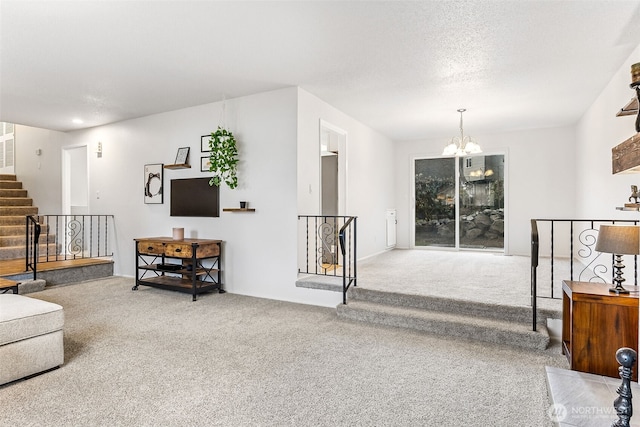 carpeted living area featuring stairway, a textured ceiling, and an inviting chandelier