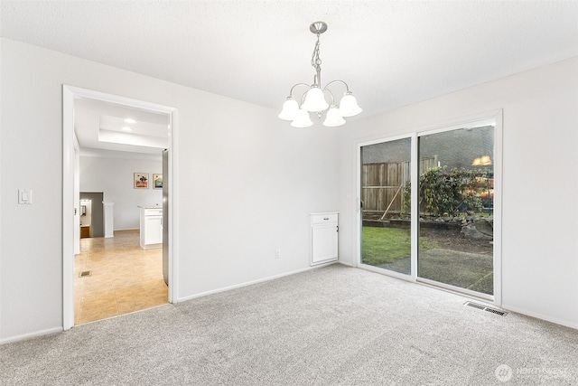 unfurnished room with visible vents, baseboards, a notable chandelier, and carpet flooring