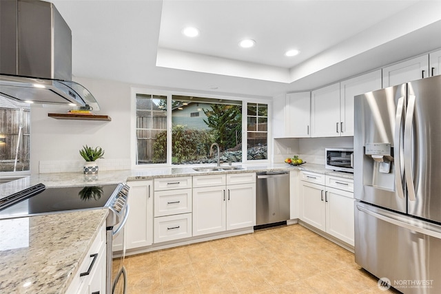 kitchen featuring a sink, light stone counters, white cabinetry, appliances with stainless steel finishes, and island range hood