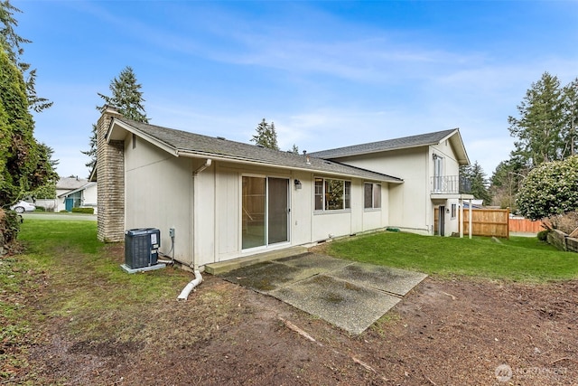 rear view of house with a patio, central AC, fence, a yard, and a balcony