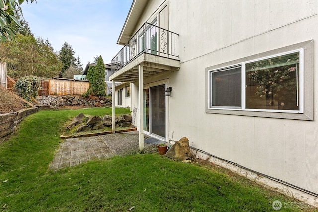 view of yard featuring a balcony and fence