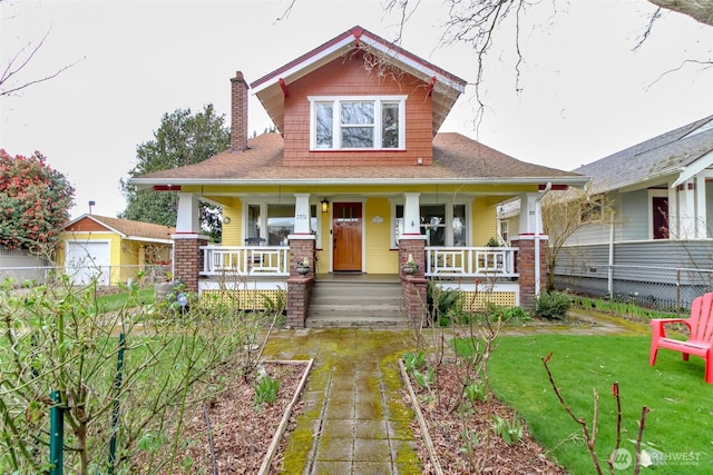 view of front of home featuring a front yard, a porch, a chimney, and fence