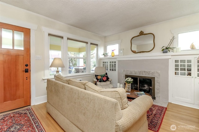 2029 S 7th St, Tacoma, WA 98405 - living room featuring light wood-style floors, baseboards, a high end fireplace, and a textured ceiling