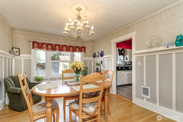 2029 S 7th St, Tacoma, WA 98405 - dining space featuring visible vents, light wood finished floors, ornamental molding, a textured ceiling, and a decorative wall
