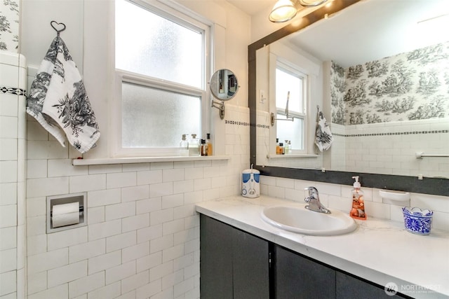2029 S 7th St, Tacoma, WA 98405 - bathroom featuring wallpapered walls, tile walls, vanity, and a wainscoted wall