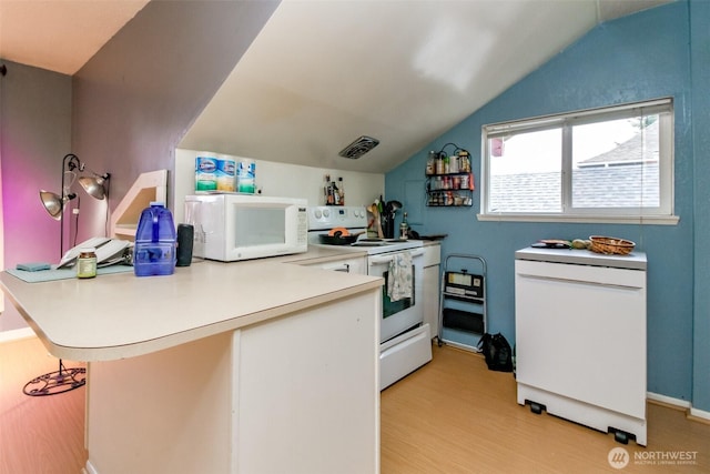 2029 S 7th St, Tacoma, WA 98405 - kitchen featuring light countertops, lofted ceiling, a peninsula, light wood-style floors, and white appliances