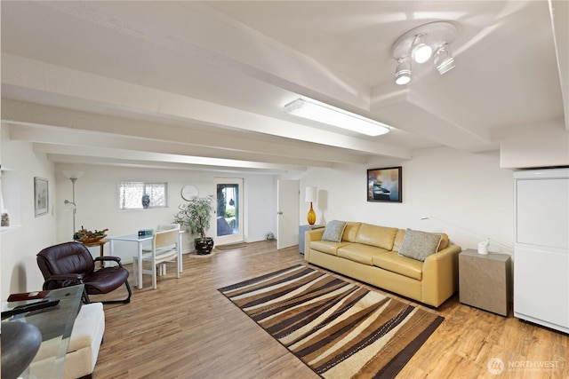 living area with beam ceiling and light wood-type flooring