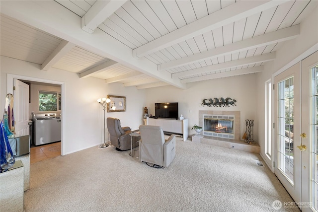 living area featuring carpet, beam ceiling, plenty of natural light, and french doors