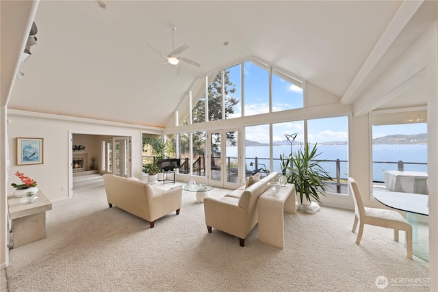 carpeted living area featuring high vaulted ceiling, a water view, and ceiling fan