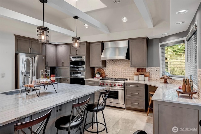 kitchen featuring beamed ceiling, light stone counters, tasteful backsplash, stainless steel appliances, and wall chimney exhaust hood