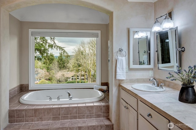 full bath featuring vanity and a garden tub