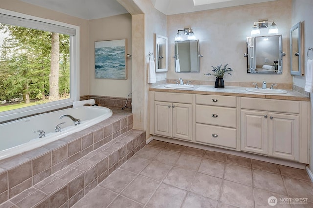 full bath featuring a bath, tile patterned flooring, double vanity, and a sink