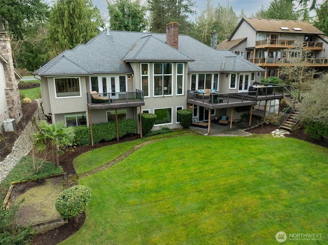 back of house with stairway, a yard, a shingled roof, a chimney, and a deck