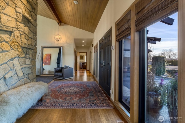 corridor with beamed ceiling, high vaulted ceiling, wood ceiling, and wood finished floors