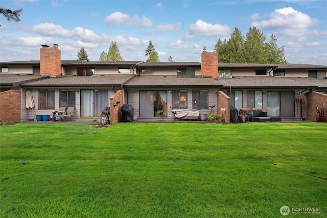 back of house with a yard, a chimney, and a patio area