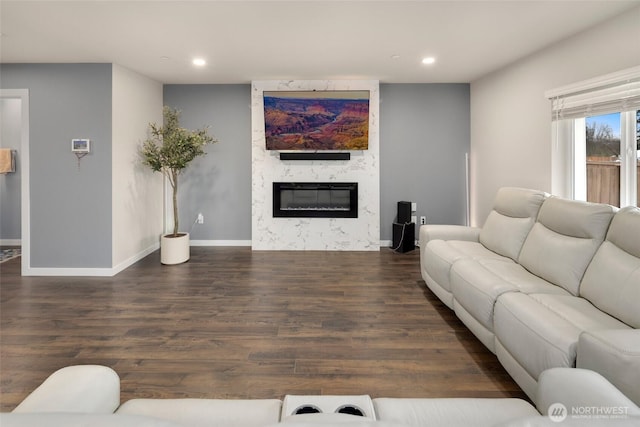 living room with recessed lighting, a fireplace, baseboards, and wood finished floors