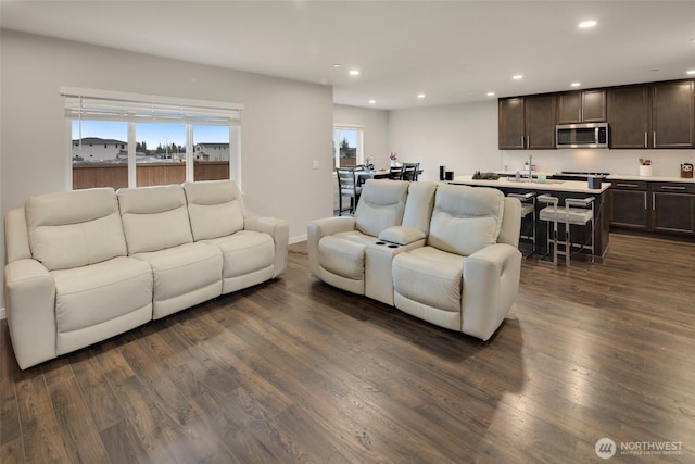 living room with recessed lighting, baseboards, and dark wood finished floors