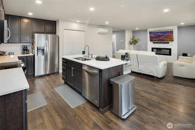 kitchen featuring a sink, appliances with stainless steel finishes, dark wood-style floors, and light countertops