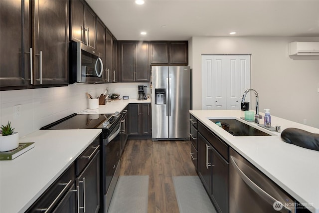 kitchen featuring appliances with stainless steel finishes, a wall mounted AC, light countertops, and a sink