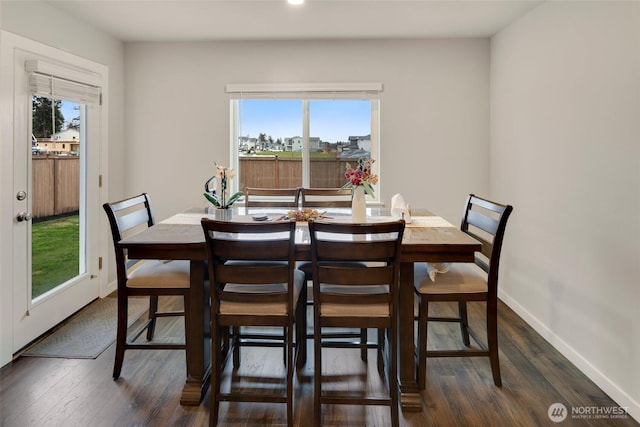 dining space with baseboards and dark wood-style flooring