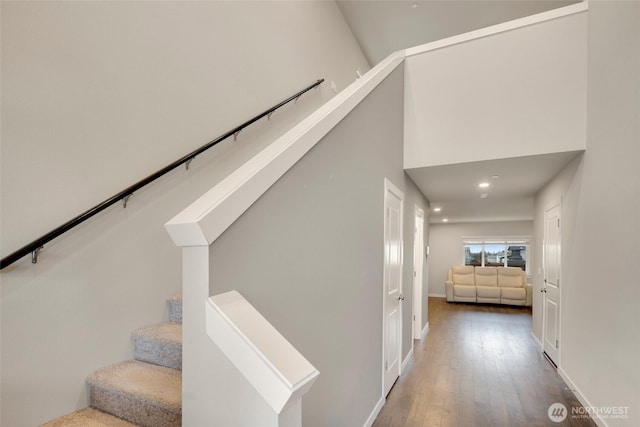 staircase featuring hardwood / wood-style flooring, recessed lighting, and baseboards