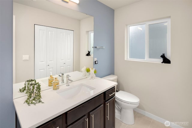 bathroom featuring tile patterned flooring, toilet, vanity, and baseboards