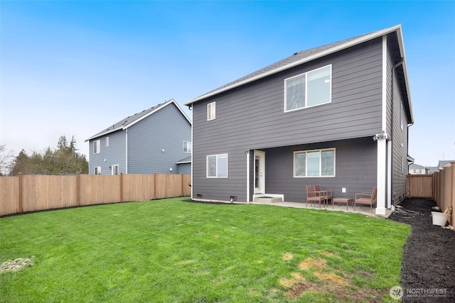 rear view of property with a yard, a fenced backyard, and a patio area