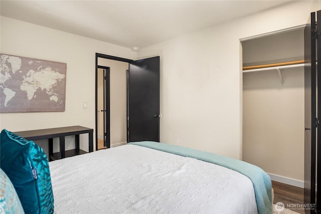 bedroom with a closet, baseboards, and wood finished floors