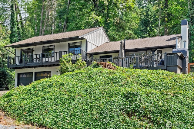 view of front of house featuring stucco siding, a balcony, an attached garage, and a shingled roof