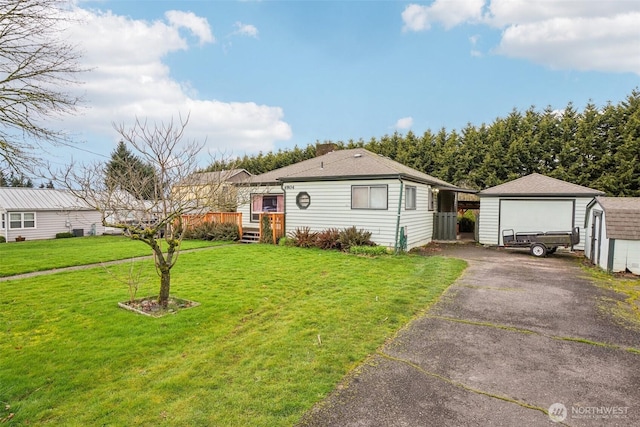 view of front of house featuring an outbuilding, a wooden deck, aphalt driveway, and a front lawn