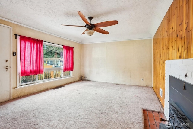 unfurnished living room featuring a textured ceiling, visible vents, carpet floors, and ceiling fan