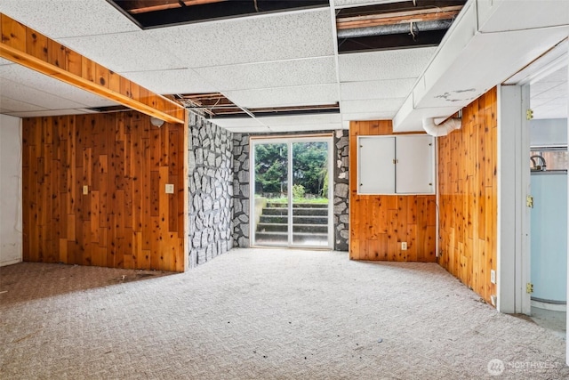 empty room featuring wooden walls and carpet flooring