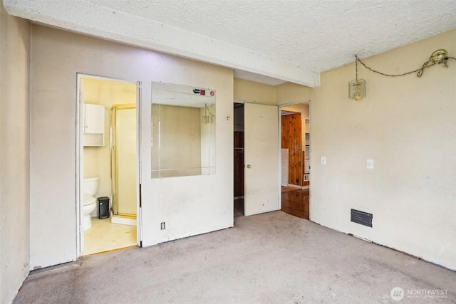 unfurnished room featuring visible vents and a textured ceiling