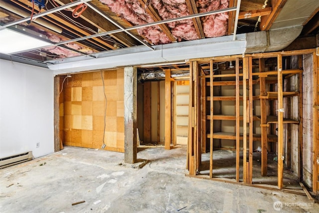 unfinished basement featuring a baseboard heating unit