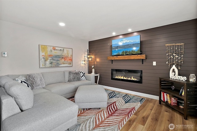 living room with recessed lighting, a large fireplace, and wood finished floors