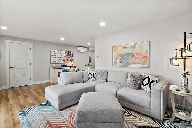 living room featuring a wall unit AC, recessed lighting, light wood-type flooring, and baseboards