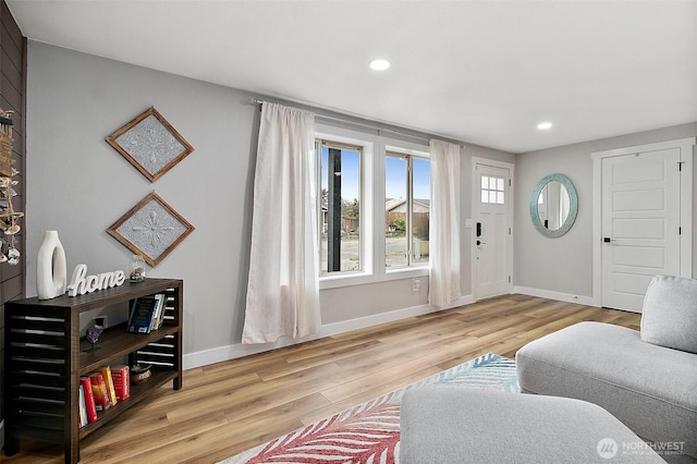 living area with recessed lighting, wood finished floors, and baseboards