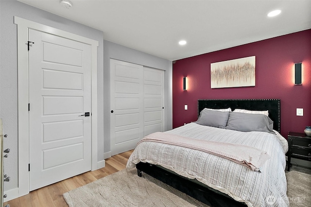 bedroom featuring light wood-style flooring, recessed lighting, a closet, and baseboards