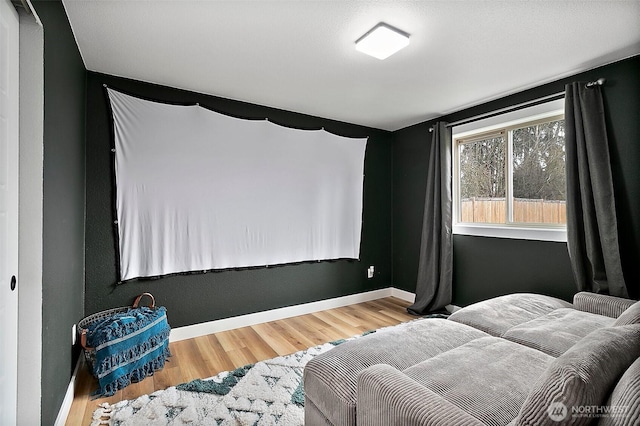 cinema room featuring wood finished floors and baseboards