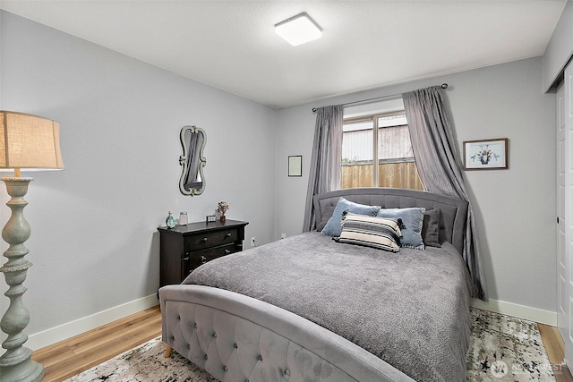 bedroom with light wood finished floors and baseboards