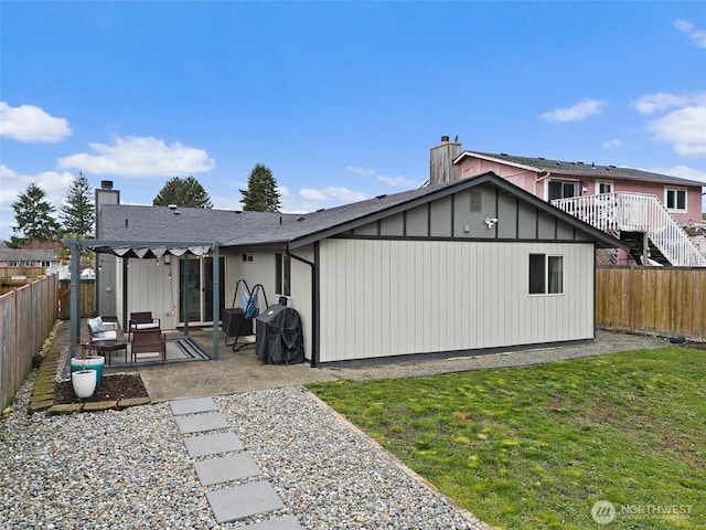 rear view of property with a patio area, a chimney, and a fenced backyard