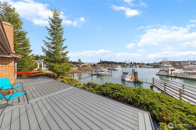 wooden deck featuring a boat dock and a water view