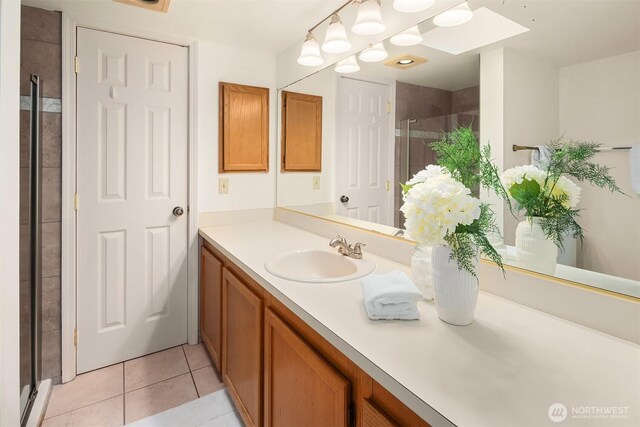 full bath with vanity, a shower stall, and tile patterned flooring