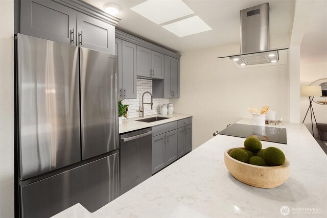 kitchen with tasteful backsplash, range hood, appliances with stainless steel finishes, gray cabinets, and a sink